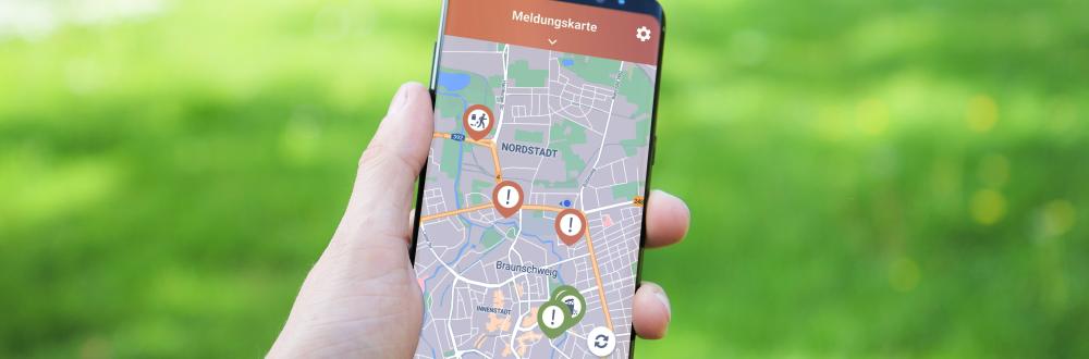 Handy in einer Handy mit Kartenansicht der App Meldoo