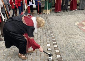 Salzwedels Bürgermeisterin Sabine Blüm setzt Steine mit den Namen der neuen Hansestädte in das Pflaster eines Platzes.