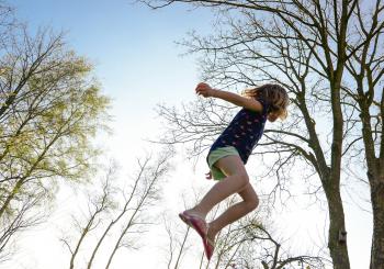 Kind springt auf einem Trampolin