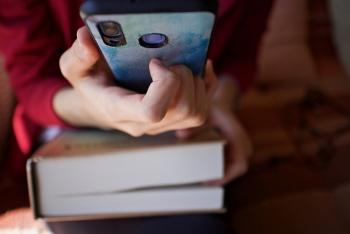 Hand hält Buch und Handy
