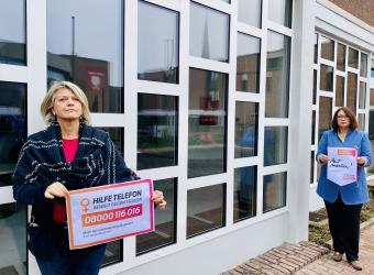 Gleichstellungsbeauftragte Regina Lenneps und Bürgermeisterin Ulrike Westkamp halten Plakate zum Orange Day gegen häusliche Gewalt 
