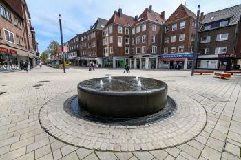 Fußgängerzone mit einem Brunnen im Vordergrund 