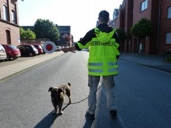 Elternlotse Kai Hübscher und Lotsenhund Joschi sichern den Schulweg an der Gemeinschaftsgrundschule Feldmark.